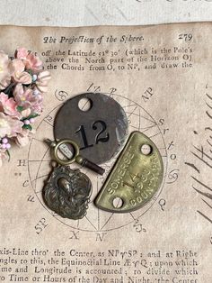 an old paper with some key chains on top of it and flowers in the background