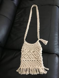 a white crocheted bag sitting on top of a black couch