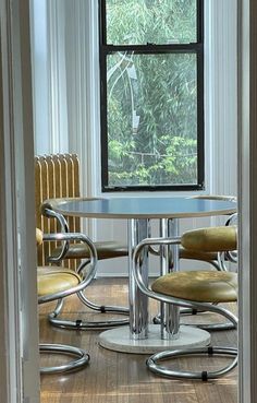 a table and chairs in front of a window