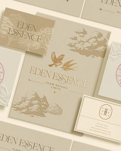 several business cards and envelopes with gold foil on them, all designed by eden essonce