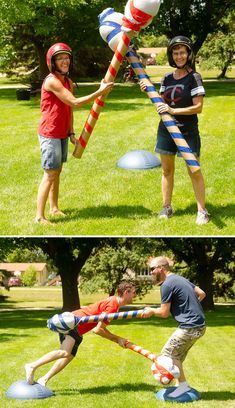 two people are playing in the grass and one is holding a large ball with a stick