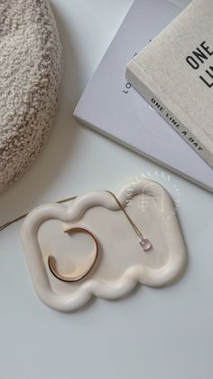 a white object sitting on top of a table next to a book