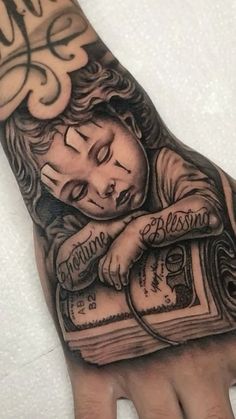 a person's hand with a tattoo on it that has an image of a child holding