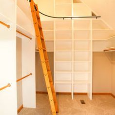 an empty room with a ladder and shelves in the corner, next to a closet