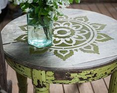 a vase filled with flowers sitting on top of a wooden table next to a chair