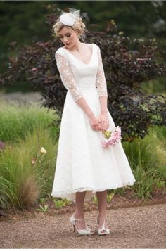 a woman in a white dress holding flowers