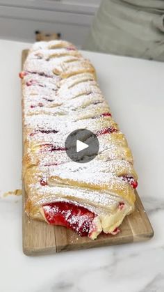 a long pastry sitting on top of a wooden cutting board