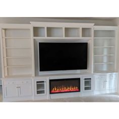 a white entertainment center with built - in fireplace and bookcases on both sides