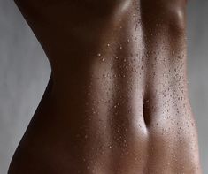 the back of a man's body with water droplets on his stomach and chest