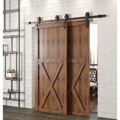 an open wooden door in front of a white brick wall with metal brackets on it