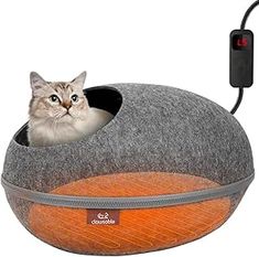 a cat is sitting in an orange and grey kitty bed with its head sticking out