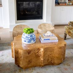 a living room with a coffee table and chairs in front of a fire place that is built into the wall