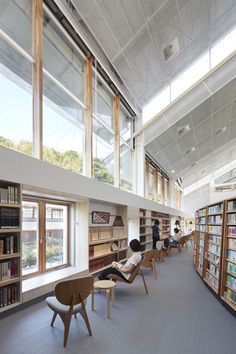 an empty library filled with lots of books and people sitting at the tables in front of them