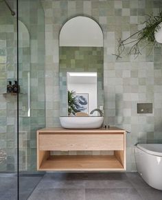 a bathroom with a sink, toilet and mirror on the wall next to each other