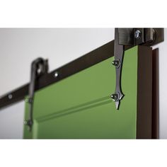 a green sliding door with two black handles