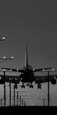 an airplane is taking off from the runway at night with lights on it's sides