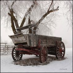 an old wooden wagon sitting in the snow