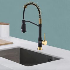 a kitchen sink with a black faucet and gold handles