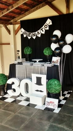 a table with balloons and decorations for a 30th birthday party in black and white colors