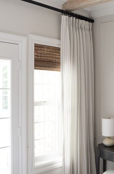 the curtains in this bedroom are pulled back from the window sill to let light into the room