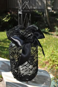 a black lace wrapped mason jar with a satin ribbon bow