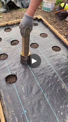 a man is using a drill to put holes in the ground