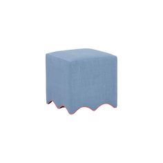 a small blue ottoman with scalloped edges on the bottom and red piping