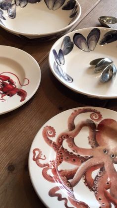 three plates with octopus designs on them sitting on a table