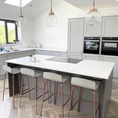 an image of a kitchen setting with white countertops and stools on the island