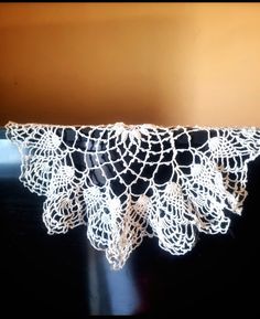 white crocheted doily on black surface in room