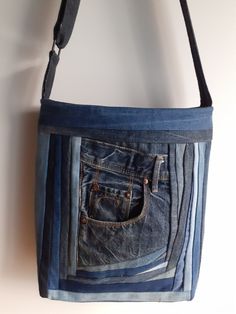 a denim bag hanging on the wall with two pockets in it and one pocket open