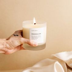 a person holding a candle in their hand with the words moonglow on it