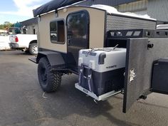 an off - road vehicle parked in front of a building with its doors open and the back door opened