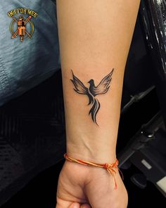 a woman's arm with a tattoo on the wrist and an orange string around it