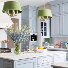 a kitchen with blue cabinets and green lamps