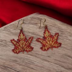 Add a touch of elegance and bohemian charm to your look with our exquisite handmade seed bead earrings. Each pair is meticulously crafted with love and attention to detail, ensuring that no two pairs are exactly alike. These earrings make a thoughtful and unique gift for birthdays, anniversaries, or just because. Red, amber, and gold leaf pattern. Made with high quality seed beads. Gold filled ear wires 3.1 x 3.5 cm. Packed in a velveteen gift bag.  Ready to ship. This is not an original design. Handwoven Round Beads Earrings As Gift, Gold Beaded Dangle Earrings For Gifts, Traditional Gold Beaded Earrings As Gift, Artisan Beaded Earrings For Festive Occasions, Festive Beaded Teardrop Earrings, Elegant Handwoven Beaded Earrings As Gift, Gift Gold Beaded Earrings, Czech Glass Beaded Dangle Earrings, Bohemian Gold Beaded Earrings For Gifts