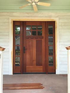 a wooden door with two windows and a fan