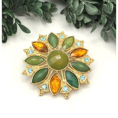 Elegant vintage brooch featuring a floral design with green and oragne rhinestones. Ideal for adding a touch of sophistication to your attire. * Gold-tone metal * Green and orange rhinestones * Floral design * Secure pin clasp * Measures approximately 2 inches in diameter item# 2A24049 Gold-tone metal shows minor wear consistent with vintage age. Measures approximately 2 inches in diameter. Gently loved Thank you for visiting our shop... Green Jeweled Brooch For Gift, Green Jeweled Brooches As Gift, Women Accessories Jewelry, American Vintage, Gold Tone Metal, Green And Orange, Vintage Brooches, Vintage Gold, Women's Accessories