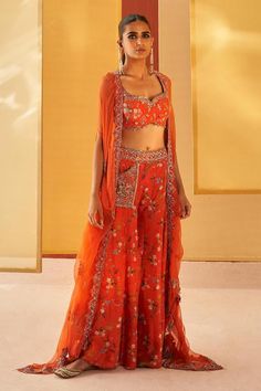 Orangish red silk organza cape with floral print and zardosi and pitta embroidery. Comes with sharara and a blouse.
Components: 3
Pattern: Printed, Embroidered
Type Of Work: Floral, Zardosi, Pitta
Neckline: Sweetheart
Sleeve Type: Cape : Flared Sleeves, Blouse : Sleeveless
Fabric: Silk organza
Color: Orange,Red
Other Details: 
Pocket detailing on sharara
Note : Outfit worn by the model on the left is not for sale.
Occasion: Mehendi and Haldi - Aza Fashions Traditional Front Open Choli With Dupatta, Embroidered Orange Palazzo Set, Traditional Front Open Sharara With Dupatta, Red Bohemian Chanderi Sets, Traditional Front Open Palazzo Set For Diwali, Festival Front Open Sharara With Dupatta, Embroidered Orange Palazzo Set For Festivals, Bohemian Palazzo Set With Floral Embroidery For Festive Occasions, Eid Front Open Sets With Floral Embroidery