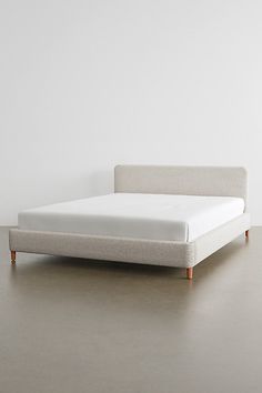 a white bed sitting on top of a gray floor