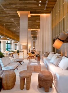 a living room filled with lots of white furniture and decor on top of carpeted flooring