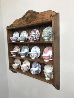 a wooden shelf filled with lots of plates on top of it's side wall