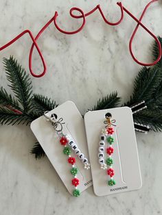 two christmas themed earrings are sitting on a table