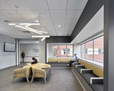 two people sitting on benches in an office