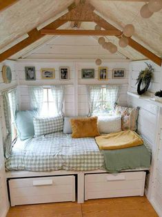 a small bed in the corner of a room with drawers underneath it and pictures on the wall