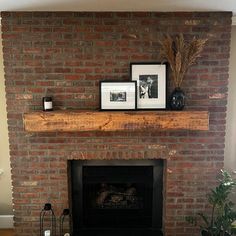 a living room with a fire place and pictures on the mantle