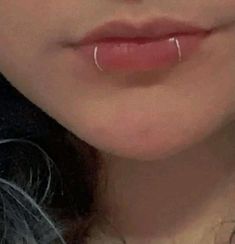 a close up view of a woman's nose with piercings