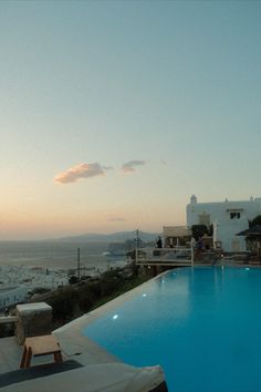 an empty swimming pool in front of the ocean