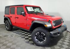 a red jeep is parked on a checkered floor