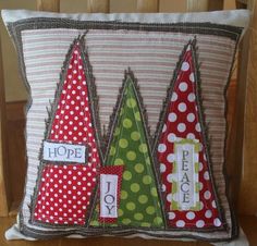 a decorative pillow with three christmas trees on the front and one saying hope, peace, joy